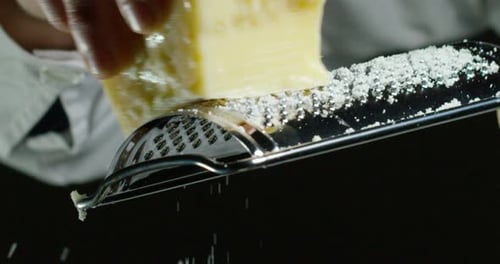 Zeitlupe von A Koch reibe Parmesankäse, typisch italienischer Käse, auf dem Teller nur frisch br