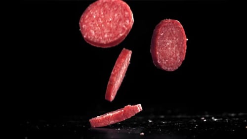 Sliced Salami Falls on Black Background Filmed on a Highspeed Camera at 1000 Fps