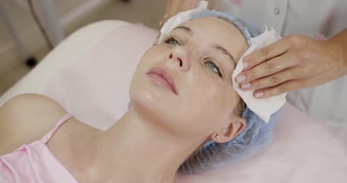 Professional Beautician Gently Cleansing Woman Face