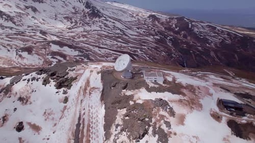 Space research radio telescope. Aerial orbit shot in high snowy peaks. Sierra Nevada. Spain.