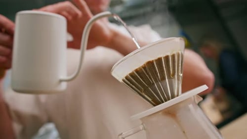 Der Prozess der Zubereitung von Filterkaffee, indem heißes Wasser über eine Schicht gemahlenen Kaffees auf dem Filter gegossen wird