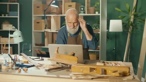 Senior Craftsman Working at Desk With Laptop