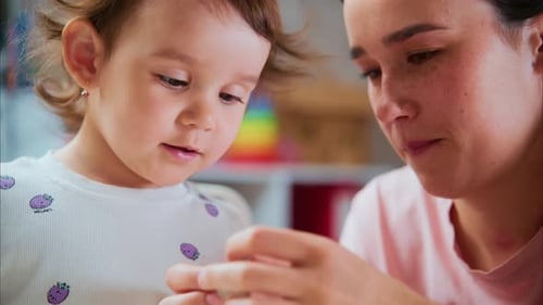 Mother and Toddler Daughter Play with Clay Indoors