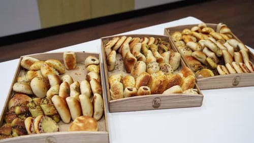 Verschiedene gebackene Grissini und Minigebäck in Holzschalen auf dem Buffettisch