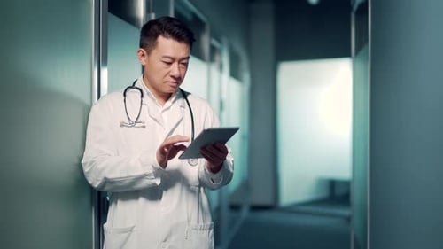 Asian male doctor advise patient remotely using digital tablet. Communicates online talks on video