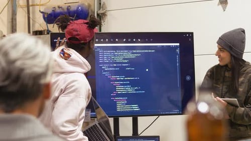 Team Discussing Code on Screen in Office
