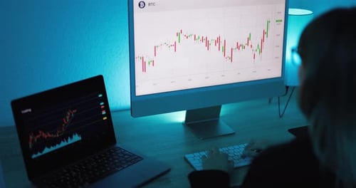 Young woman trading bitcoin cryptocurrency online late at night in the USA