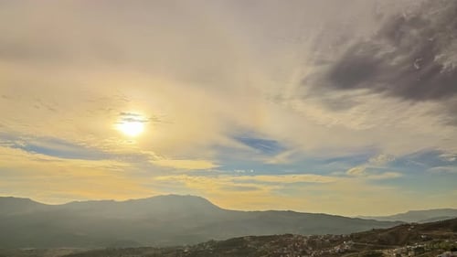 Sonnenlicht hinter Wolken am Himmel über den Bergen bei Sonnenaufgang und Sonnenuntergang. Zeitraffer