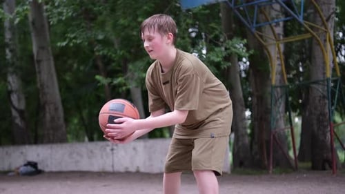 Focused Boy Training Basketball in Playground Sporty Teenage Boy with Ball in Slow Motion Street