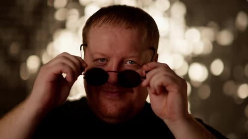 Man Puts On Round Sunglasses in Close Up