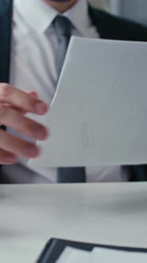 Businessman Reviewing and Stamping Documents at Desk