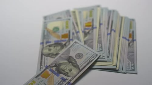 Mehrere tausend US-Dollar fallen auf den Tisch: 100 Banknoten