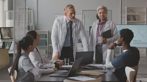 Head Physician Speaking to Multiethnic Doctors Team in Office