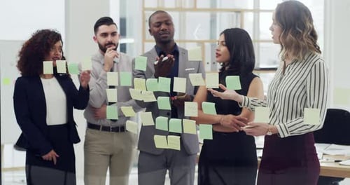 4k video footage of a group of businesspeople brainstorming with notes on a glass wall in an office