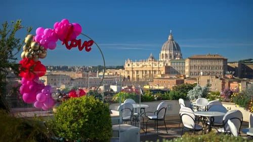 Pink, red and gold, love balloon arch at a restaurant with panoramic view of Vatican City, Rome, Ita