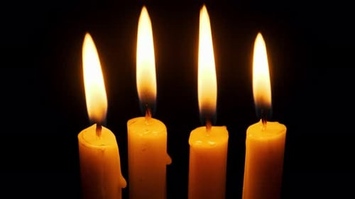 Four Candles Burning and Extinguished on a Black Background Copy Space