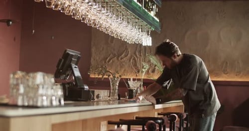 Male Administrator Wiping Bar Counter with Napkin