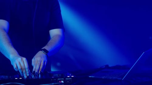 DJs Hände beim Einstellen des Soundmixers unter den Clublichtern