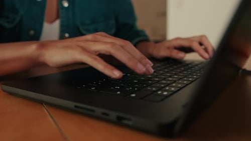 Woman hands using typing on laptop notebook keyboard sit at home close up side view