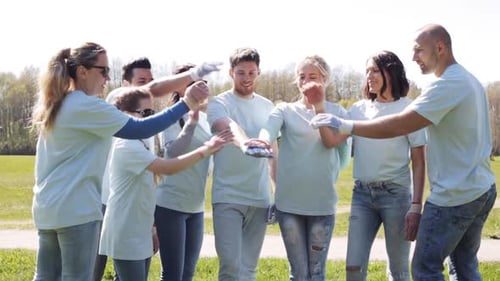 Volunteers united hands on top in the park a symbol of ecology and community