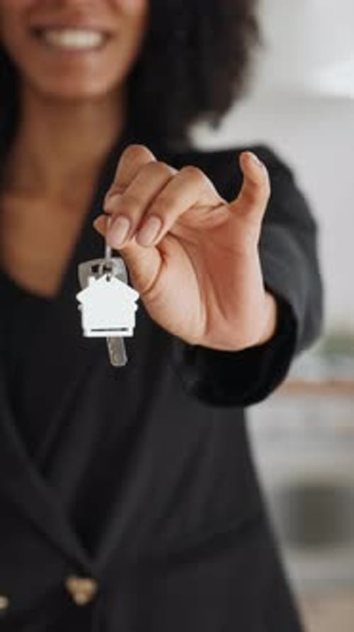 Woman Real Estate Broker Holding Keys of New Apartment in Hands Closeup View Elderly Spouses