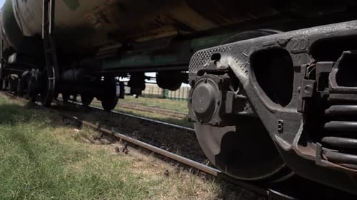 Rodas de trens de carga ferroviária se movem para a estação de plataforma com vagões