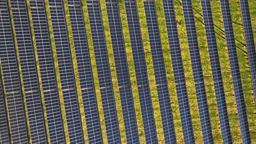 Aerial footage of photovoltaic arrays on open spaces.