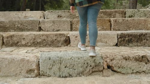 Person Ascending Ancient Stone Steps at Ruins