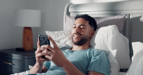 Young Adult Relaxing in Bed with Smartphone