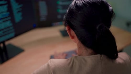 Close-up of an Indian working on a desktop computer in a startup office. Experts are coding software