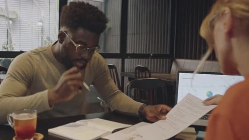 Colleagues Working on Business Plan in Modern Cafe