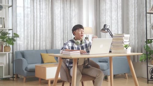 Young Adult Studying at Desk Using Laptop