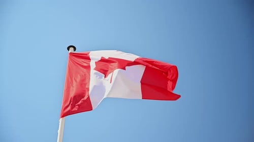 Canadian Flag Waving Against a Blue Sky