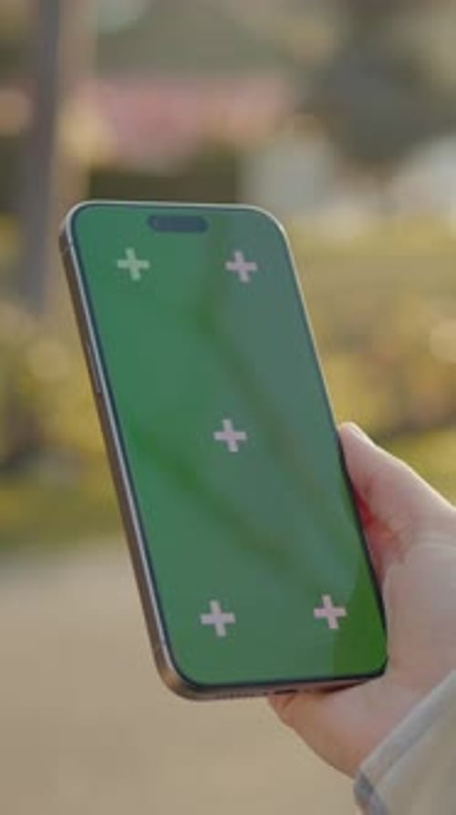 Vertical Screen Woman Holding Smartphone with Green Screen in Park