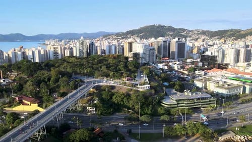 Drone aerial scene of Hercílio Luz bridge and Parque da luz with large urban center of the capital o