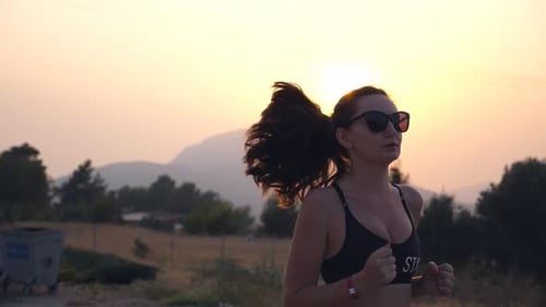 Sporty Girl Jogging in Country Road at Sunset Young Woman Running Outdoors Healthy Active Lifestyle