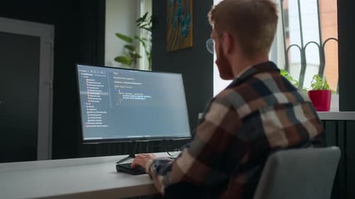 Data Scientist Writing Code Working in Office IT Company or Freelancer in Home View Over Shoulder