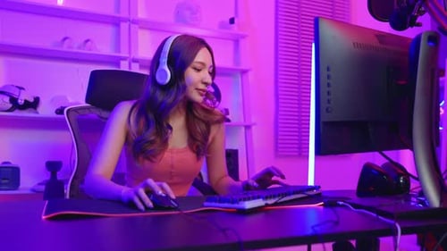 Woman Puts on Headphones and Plays Computer Games