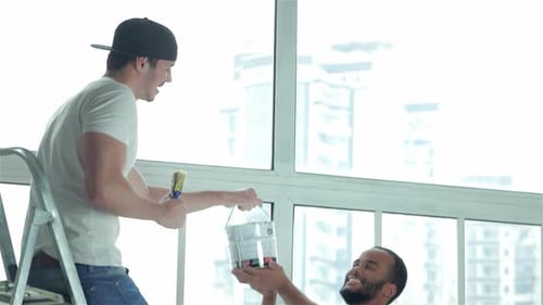 Men Smiling and Working Together to Paint