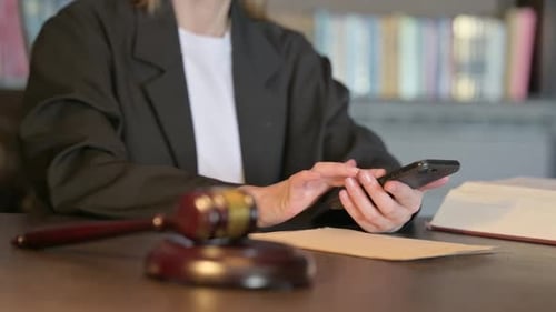 Close Up of Young Judge using Smartphone in Court