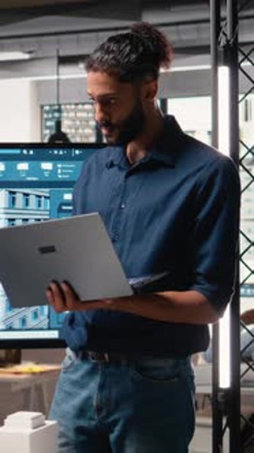 Man Works on Laptop in Modern Office Environment