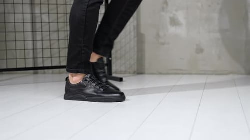 Person Showing Black Leather Shoes in Studio