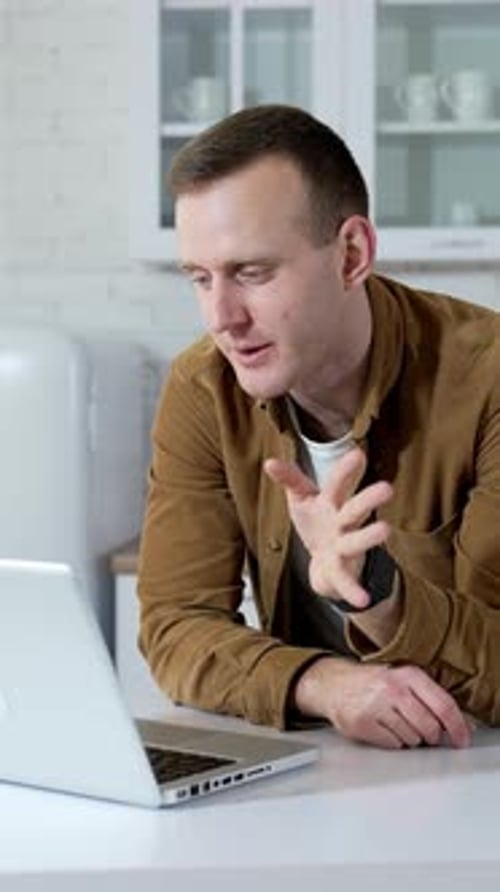 Young Adult Video Calling on Laptop in Kitchen