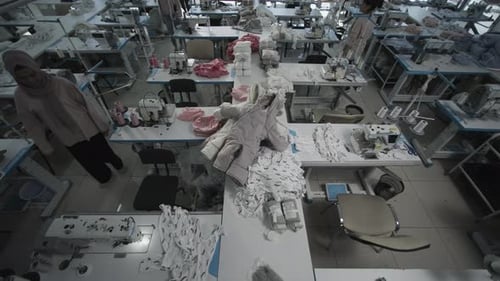 Workers in a Textile Factory are Sewing and Assembling Garments in a Production Line