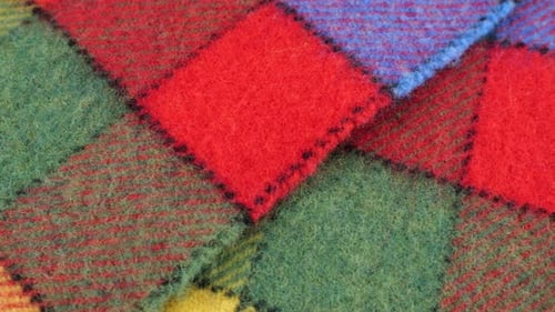Top view on the bright textured multicolored wool fabric in a large check rotated