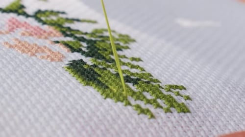 Close Up Needle Stitching Green Thread on Cross Stitch Fabric
