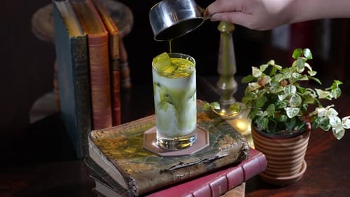 Dieses Video zeigt, wie Matcha-Sauce auf einem Tisch in Milch gegossen wird