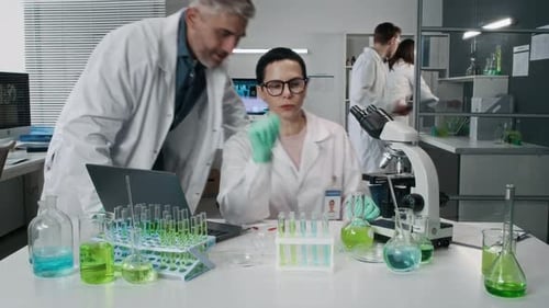 Scientists Work in Modern Lab with Microscope and Equipment