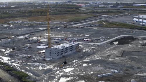 Aerial view of a large construction site with crane. Stock footage. Wasteland of the industrial area