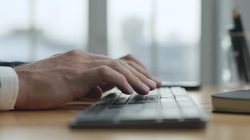 Hands Typing on Wireless Keyboard in Office Setting